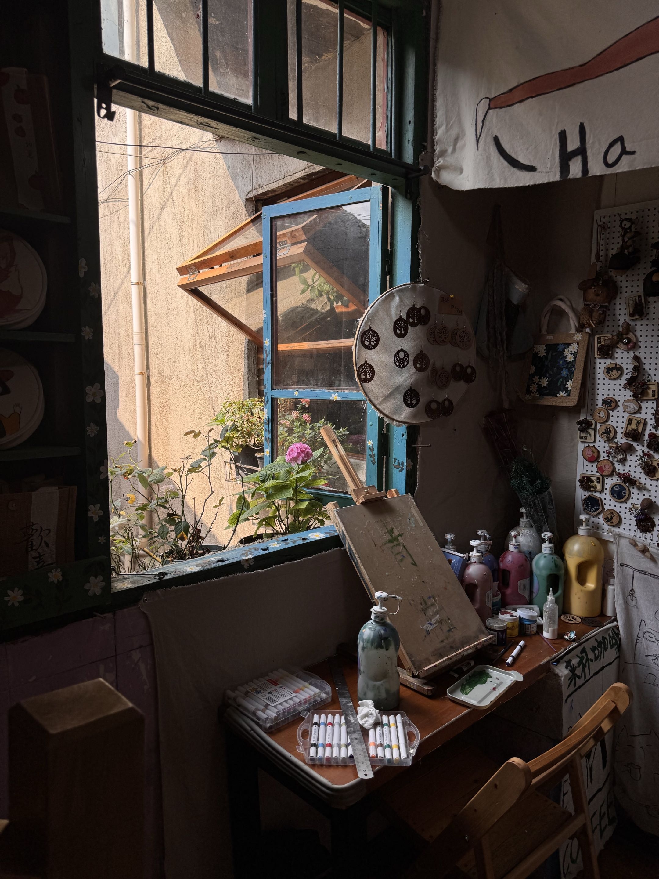 A warmly lit artist workspace beside an open blue window
