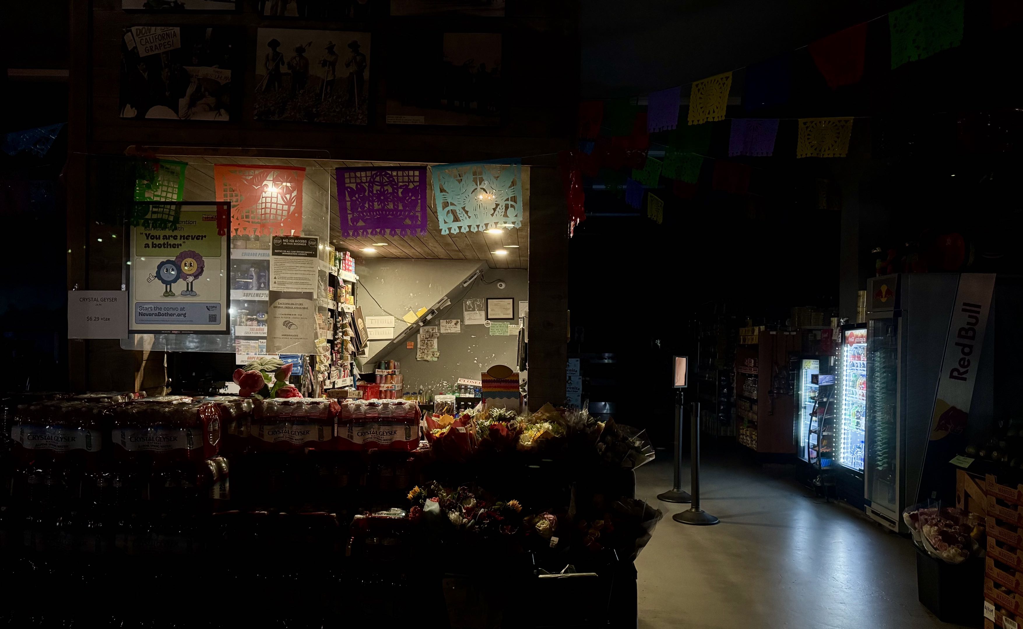 A dimly lit shop interior with colorful papel picado decorations
