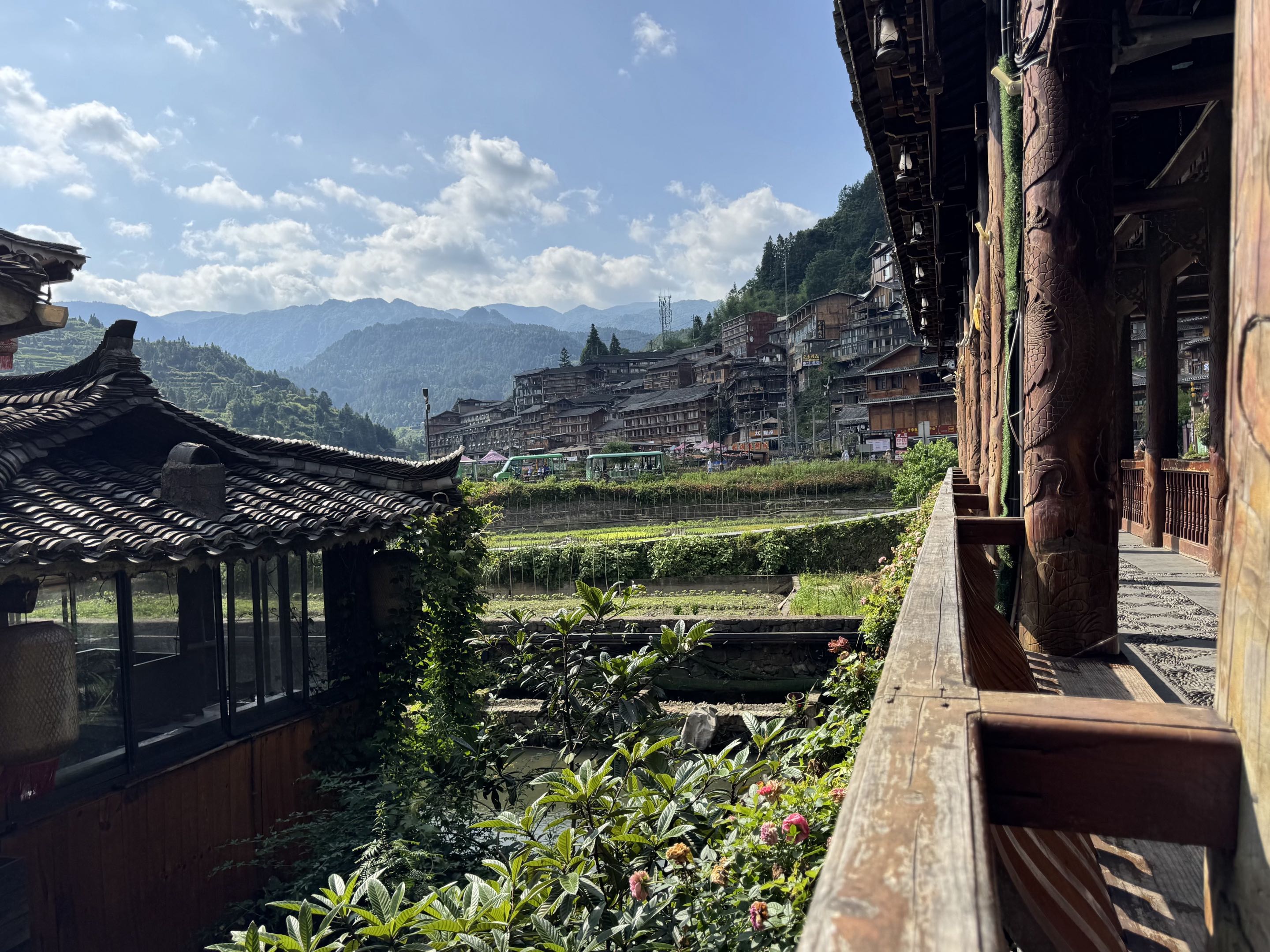 A balcony overlooking a mountain village under a blue sky